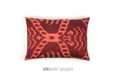 an orange and red pillow on a white background with the words silk & silk project