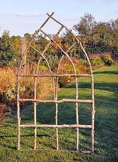 an old iron garden trellis sitting in the grass