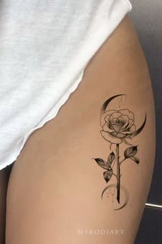 a woman's thigh with a rose tattoo on it