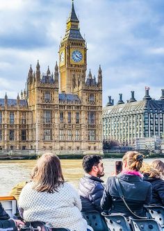 some people are riding on a boat in front of big ben and the palace of westminster