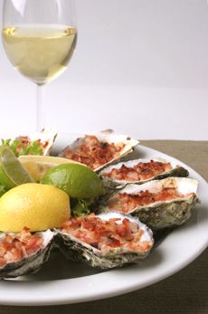 a plate with oysters and a glass of wine