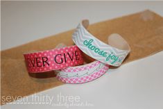 three paper bracelets that say never give and choose your own words on each one