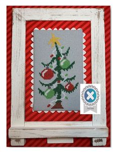 a cross stitch christmas tree on a red and white striped background