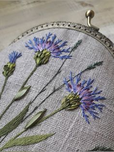 a close up of a bag with flowers embroidered on the front and back of it