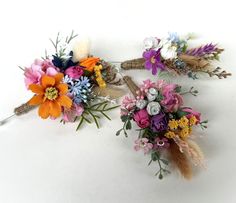 two bouquets of flowers sitting on top of each other in front of a white background