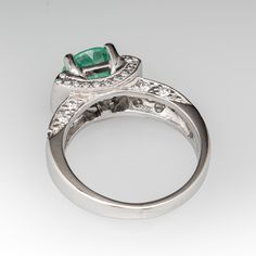 This glamorous ring is centered with one (1) round cut Seafoam tourmaline in a four-prong setting. The ring is accented with two (2) bezel set baguette cut diamonds, and forty-two (42) bead set round brilliant cut diamonds. The ring measures 7.8mm at the top, rises 8.2mm above the finger, tapering to 3.1mm wide and 1.4mm thick at the base of the shank. It is currently a size 7.25. Timeless Emerald Ring With Bezel Setting For Anniversary, Emerald Ring With Center Stone In 14k White Gold, Emerald Baguette Cut Ring For Promise, Classic Emerald Diamond Ring With Accent Stones, Round Emerald Ring With Diamond Accents, Elegant Halo Ring With Bezel Setting, Formal Bezel-set Baguette-cut Emerald Ring, Formal Baguette Cut Emerald Ring With Bezel Setting, Diamond Sapphire Ring With Accent Stones For May Birthstone