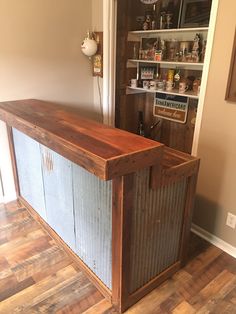 an empty bar in the corner of a room with wooden flooring and shelving