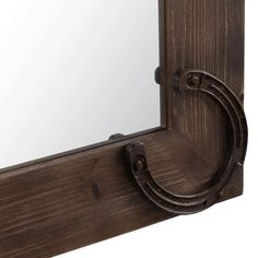 a mirror that is on the side of a wooden frame with a metal ring around it