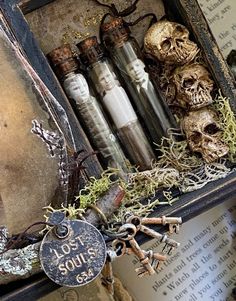 an old box filled with bottles and skeleton heads sitting on top of a table next to books