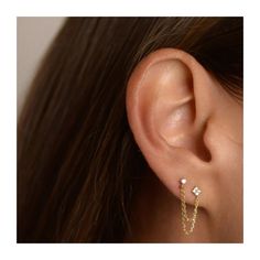 a woman's ear is shown with gold and diamond earrings on it, including the letter v