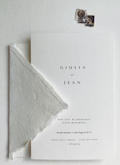 the wedding stationery is laid out on top of each other, with a postage stamp