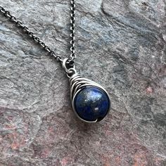 A genuine Lapis Lazuli stone has been wrapped in sterling silver. The pendant hangs from a sterling silver chain. The end of the chain features a lobster claw clasp and a 3-inch extender chain allowing the necklace to be slightly adjustable in length.Be sure to see all photos and video for size and color reference.Lapis Lazuli: About 8mmSelect your desired finish and necklace length when ordering. The necklace photographed is shown at an 18-inch length modeled on a women's size S/M mannequin wit Smoky Quartz Pendant, Lapis Lazuli Pendant, Lapis Lazuli Necklace, Silver Pearl Necklace, Lapis Lazuli Stone, Hammered Sterling Silver, Opal Pendants, Quartz Necklace, Quartz Pendant