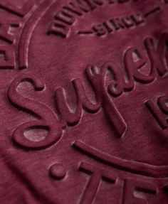 a red shirt with the words superdry printed on it's front and back