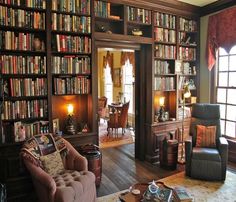 a living room filled with lots of furniture and bookshelves covered in bookcases