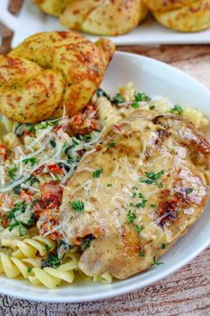 a white plate topped with pasta and meat covered in sauce