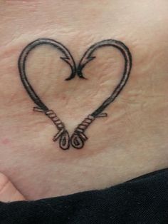 a woman's stomach with a heart shaped tattoo on it