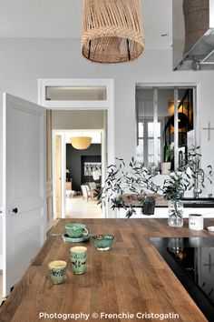 a kitchen counter with bowls on it and a basket hanging from the ceiling over it