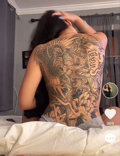 the back of a woman's body with tattoos on it