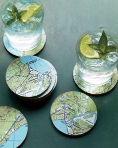 four coasters with maps on them sitting on a table next to a glass of water