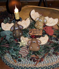 a wooden bowl filled with ornaments and a lit candle