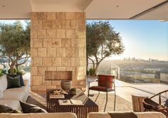 a living room filled with furniture next to a large window covered in glass and stone