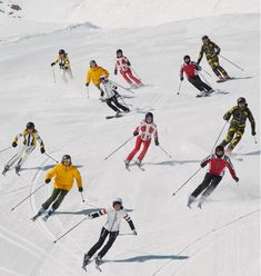 a group of people riding skis down a snow covered slope