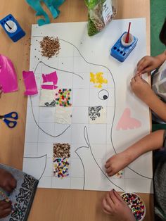 two children are making crafts with paper and crafting supplies on a table top,