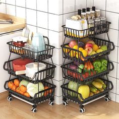 two black metal baskets filled with fruits and vegetables on top of a wooden floor next to a white tiled wall