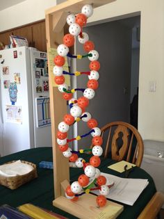 an orange and white bead necklace is on a shelf in front of a refrigerator