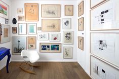 a room filled with lots of framed pictures on the wall