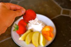 a person is picking up some fruit from a plate