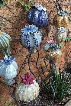 there are many different colored vases on this planter and it is next to a stone wall