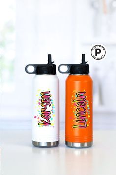 two water bottles sitting next to each other on top of a white table with the words happy new year written on it