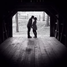 two people are kissing in an open barn