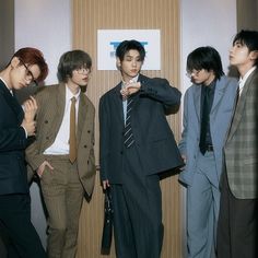 four young men in suits standing next to each other