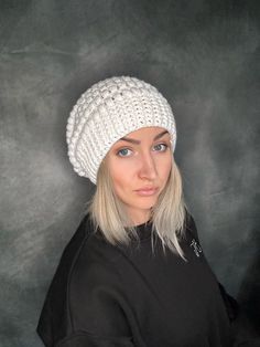 This white crochet beanie is the perfect accessory to add a touch of cozy and style to your outfit. Handmade with incredible attention to detail, this hat is made from soft, high-quality Aran that will keep you warm and comfortable. Its slouchy design adds a trendy and relaxed look, while the one-size-fits-all feature makes it a versatile choice for anyone. Whether you're going for a casual daytime look or need a stylish headcovering for cooler weather, this beanie hat is a must-have. Add it to White Crochet Beanie, Crochet Bonnet, Crochet Slouchy Beanie, Bonnet Au Crochet, Slouchy Hats, Slouchy Beanie Hat, Bonnet Crochet, White C, Slouchy Hat