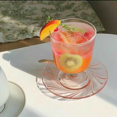 a glass filled with a fruity drink sitting on top of a table