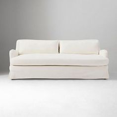 a white couch sitting on top of a white floor