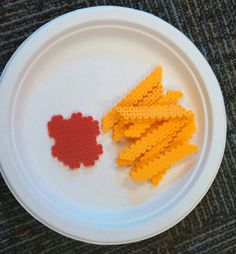 a white plate topped with yellow and red lego pieces