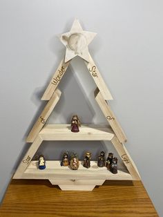 a wooden shelf with figurines on it and a star hanging from the top