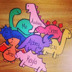 colorful dinosaur name tags on a wooden table