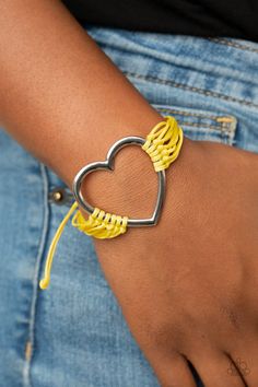 Layers of yellow cords delicately knot around an oversized silver heart charm, creating a whimsical centerpiece around the wrist. Features an adjustable sliding knot closure.

 Sold as one individual bracelet. Whimsical Centerpiece, Adjustable Sliding Knot, Sliding Knot Closure, Yellow Bracelet, Infinity Charm, Infinity Heart, Heart Strings, Knot Bracelet, Yellow Earrings