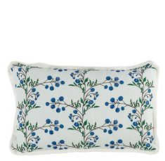 a white pillow with blue berries and green leaves on the front, against a white background