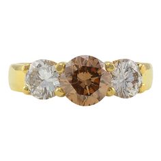 This is part of Chairish’s Fine Jewelry assortment.  Estate 18K yellow gold 1.35 carat light brown diamond ring. This ring has a center round brilliant diamond at 1.35 carats and two side round brilliant diamonds, one at 0.61 carats and one at 0.59 carats, SI1 clarity H-I color. This estate diamond ring is a size 7. This estate brown diamond ring is appraised at $11,000.  Metal: 18k Gold,Yellow Gold Stone: Diamond,Brown Diamond Stone Cut: Brilliant Cut Brown Round Diamond Ring In Fine Jewelry Style, Brown Diamond Ring In Fine Jewelry Style, Brown Diamond Ring With Diamond Accents For Anniversary, Brown Diamond Ring Fine Jewelry, Brown Diamond Ring With Accents For Anniversary, Anniversary Brown Diamond Ring With Accents, Brown Round Diamond Ring, Fine Jewelry Brown Diamond Ring, Brown Diamond Ring