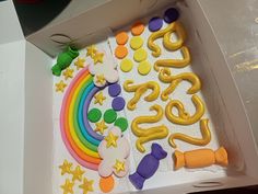 there is a cake in the shape of a rainbow with stars and letters on it