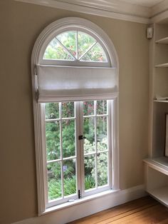 an arched window in the corner of a room