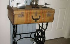 an old fashioned sewing machine sitting on top of a wooden table next to a white door