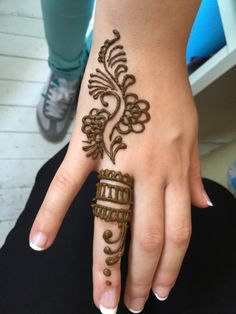 a woman's hand with henna tattoos on it