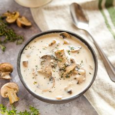 a bowl of soup with mushrooms on the side