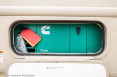 an open window on a bus with a red umbrella and other items in the back